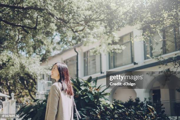 smiling asian girl walking and enjoying the nice weather in university campus - campus tour stock pictures, royalty-free photos & images