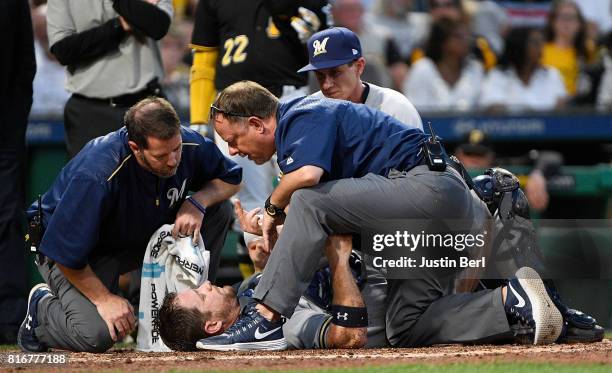 Stephen Vogt of the Milwaukee Brewers is checked out by trainers after a collision at home plate with Chad Kuhl of the Pittsburgh Pirates in the...