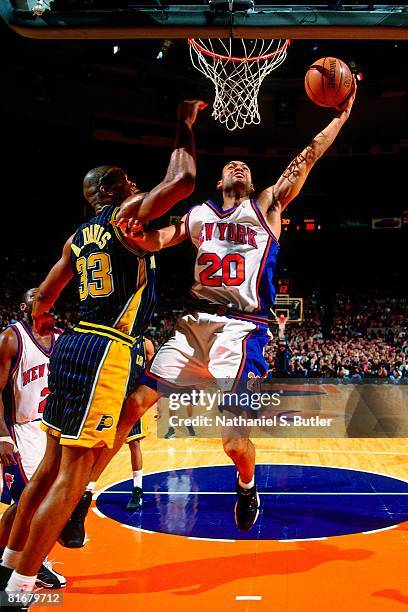 Allan Houston of the New York Knicks shoots a layup against Antonio Davis of the Indiana Pacers in Game Four of the Eastern Conference Semifinals...