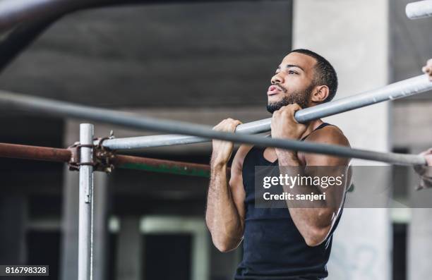 atleta masculino haciendo dominadas en un gimnasio - flexión de brazos fotografías e imágenes de stock