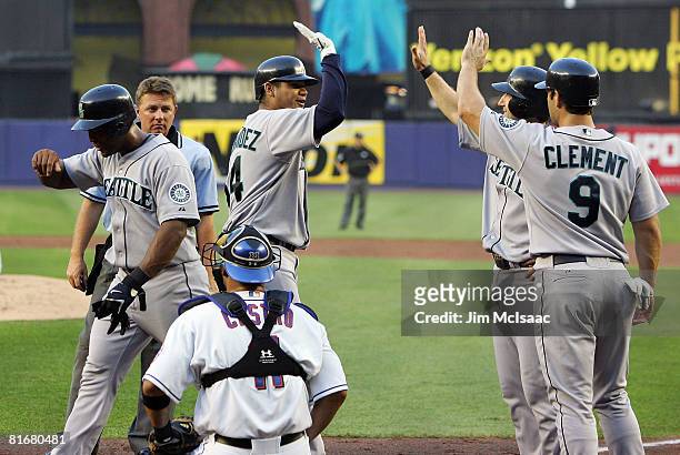 Felix Hernandez of the Seattle Mariners is met at home by teammates Jeff Clement , Willie Bloomquist, and Adrian Beltre after his second inning grand...