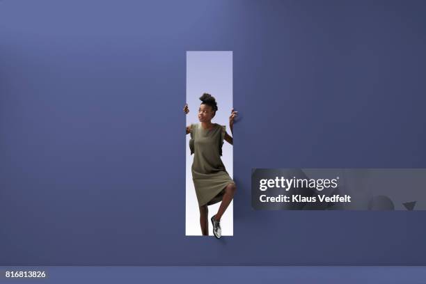 woman standing in rectangular opening of coloured wall - pre opening stockfoto's en -beelden