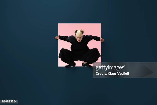 woman sitting inside square opening in coloured wall - seghet bildbanksfoton och bilder