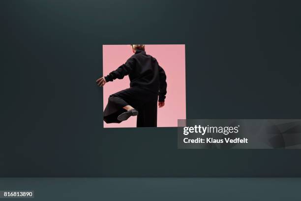 woman stepping threw square opening in coloured wall - change concept bildbanksfoton och bilder