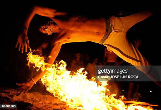 Younth jumps over a bonfire early on June 24 during the traditional San Juan night on a beach in the southern Spanish city of Malaga. Fires are lit...