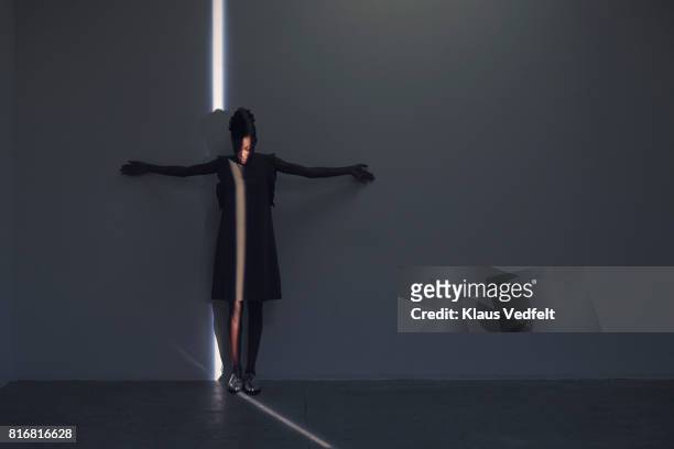 woman standing in thin light stripe, in studio with concrete floor - appearance imagens e fotografias de stock