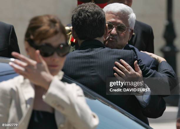 Palestinian president Mahmud Abbas hugs French President Nicolas Sarkozy near First Lady Carla Bruni-Sarkozy during a welcoming ceremony in the West...