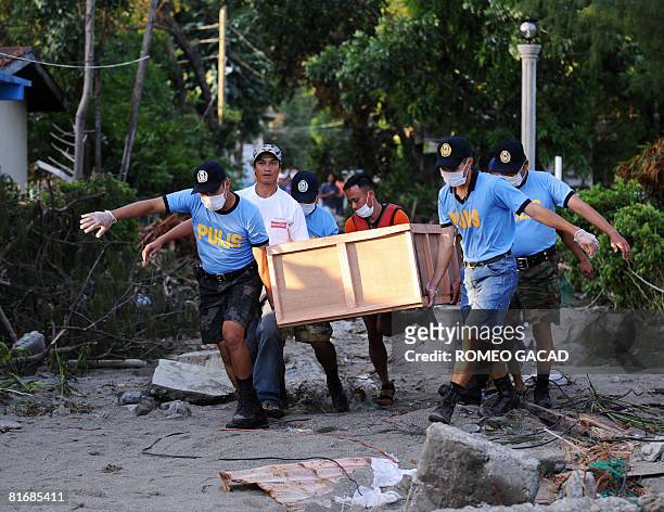 Policemen of the typhoon-hit Sibuyan island in central Philippines carry an improvised coffin bearing the body of a passenger from the sunken ferry...