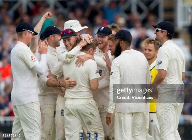 Joe Root and the England team congratulate Liam Dawson for taking the wicket of Hashim Amla during the third day of the second test between England...