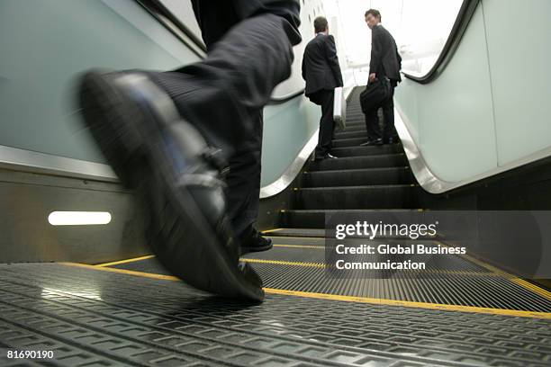 close-up of businessman's feet on escalator - running up an escalator stock pictures, royalty-free photos & images