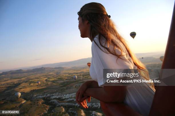 young woman explores cappadocia landscape from hot air balloon - hot air balloon people stock pictures, royalty-free photos & images