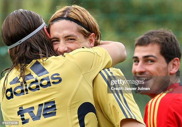 Fernando Torres of Spain is embraced by his teammate Sergio Ramos flanked by goalkeeper Iker Casillas during a training session at the Kampl training...