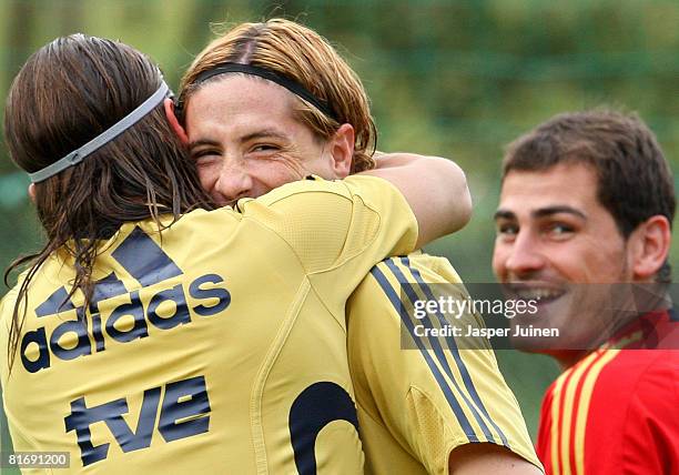 Fernando Torres of Spain is embraced by his teammate Sergio Ramos flanked by goalkeeper Iker Casillas during a training session at the Kampl training...