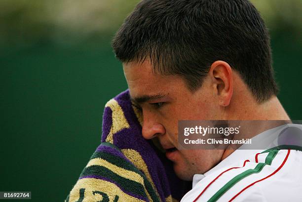 Jamie Baker of United Kingdom wipes his face during the men's singles round one match against Stefano Galvani of Italy on day two of the Wimbledon...