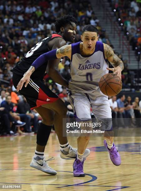 Kyle Kuzma of the Los Angeles Lakers drives past Caleb Swanigan of the Portland Trail Blazers during the championship game of the 2017 Summer League...