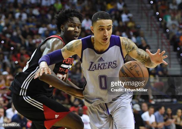 Kyle Kuzma of the Los Angeles Lakers drives past Caleb Swanigan of the Portland Trail Blazers during the championship game of the 2017 Summer League...