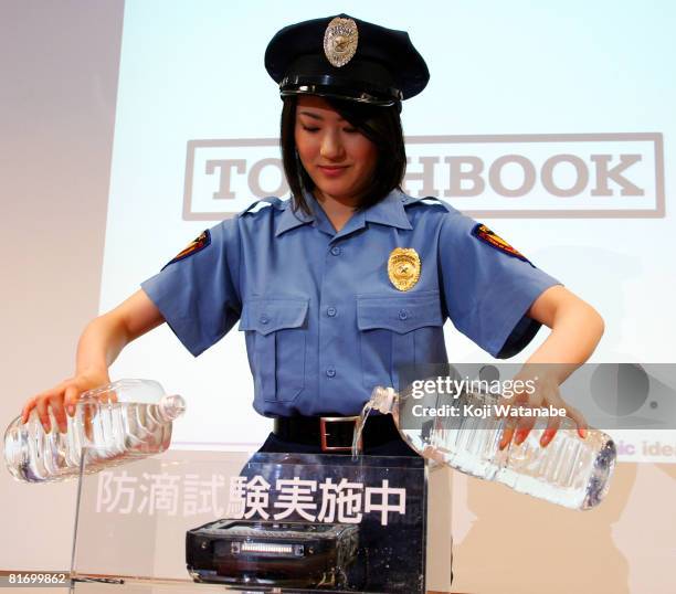 Model demonstrates the durability of Matsushita Co Ltd's new Panasonic notebook computer "Toughbook CF-U1" by pouring water at World Trade Center...