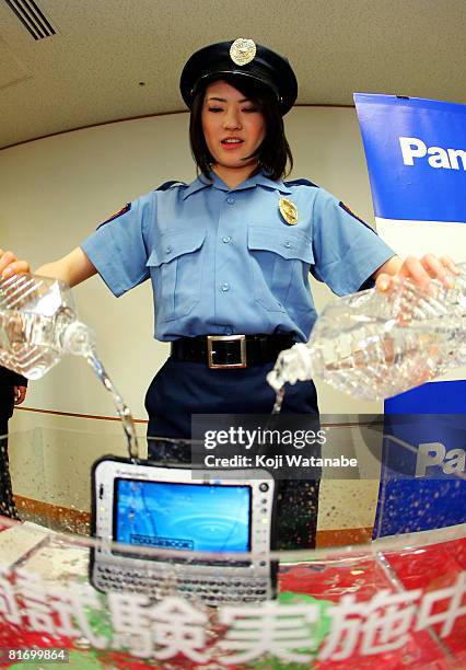 Model demonstrates the durability of Matsushita Co Ltd's new Panasonic notebook computer "Toughbook CF-U1" by pouring water at World Trade Center...