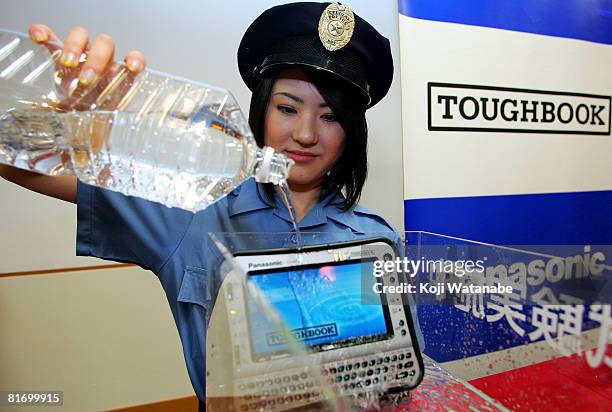 Model demonstrates the durability of Matsushita Co Ltd's new Panasonic notebook computer "Toughbook CF-U1" by pouring water on it at World Trade...