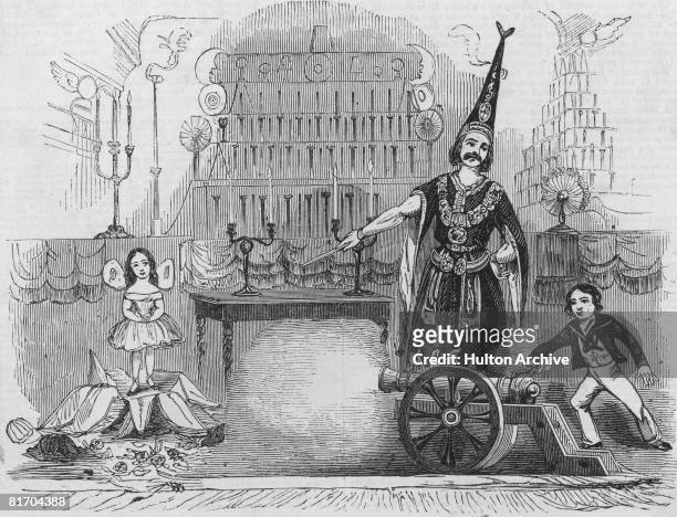 Magician Monsieur Philippe performing a trick involving two children and a small artillery piece at the Strand Theatre, London, circa 1850.