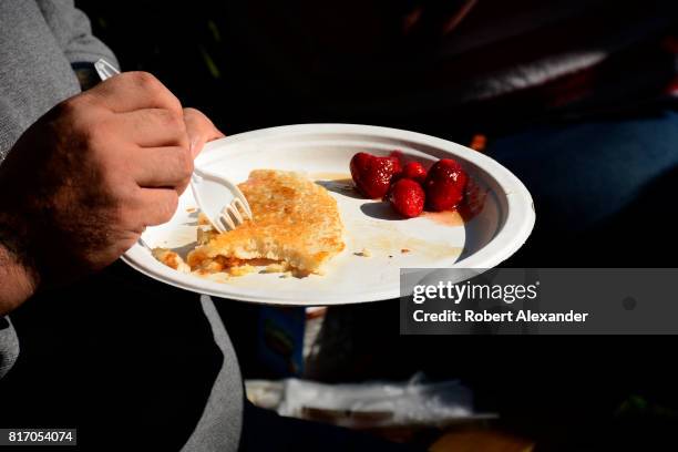 Customer enjoys his breakfast at an annual Fourth of July 'Pancakes on the Plaza' Rotary Club fundraising event in Santa Fe, New Mexico.