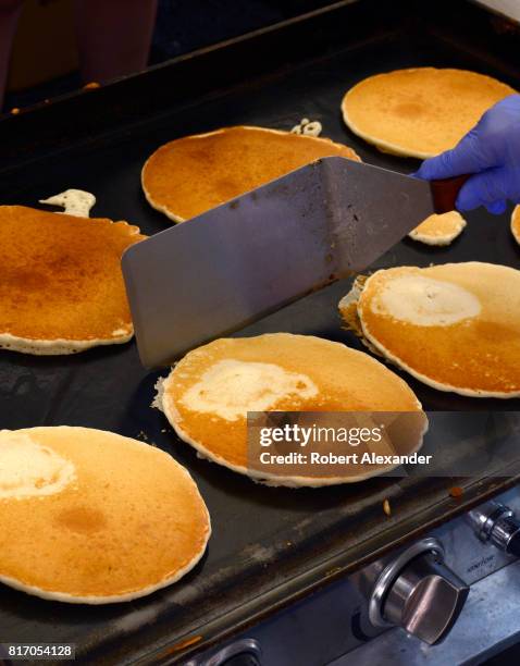 Volunteers cook and serve pancakes at an annual Fourth of July 'Pancakes on the Plaza' Rotary Club fundraising event in Santa Fe, New Mexico.