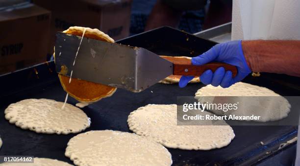 Volunteers cook and serve pancakes at an annual Fourth of July 'Pancakes on the Plaza' Rotary Club fundraising event in Santa Fe, New Mexico.