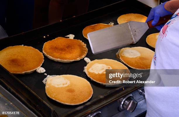 Volunteers cook and serve pancakes at an annual Fourth of July 'Pancakes on the Plaza' Rotary Club fundraising event in Santa Fe, New Mexico.
