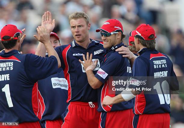 Andrew Flintoff of Lancashire is congratulated by his team mates after taking the wicket of Adam Voges during the Twenty20 Cup match between...