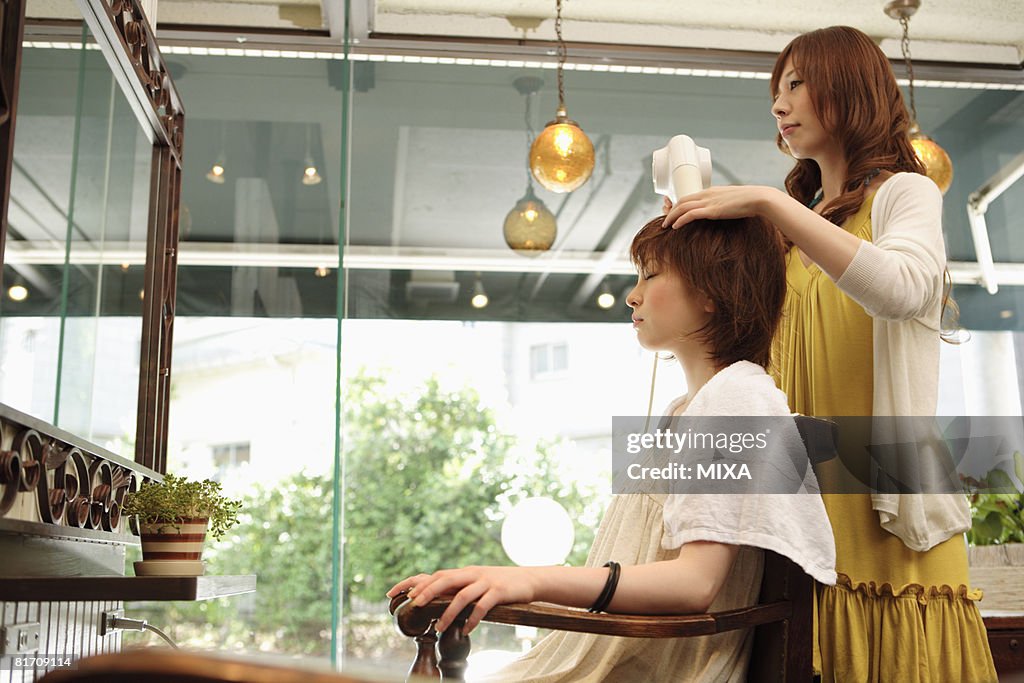 Hairdresser drying woman's hair