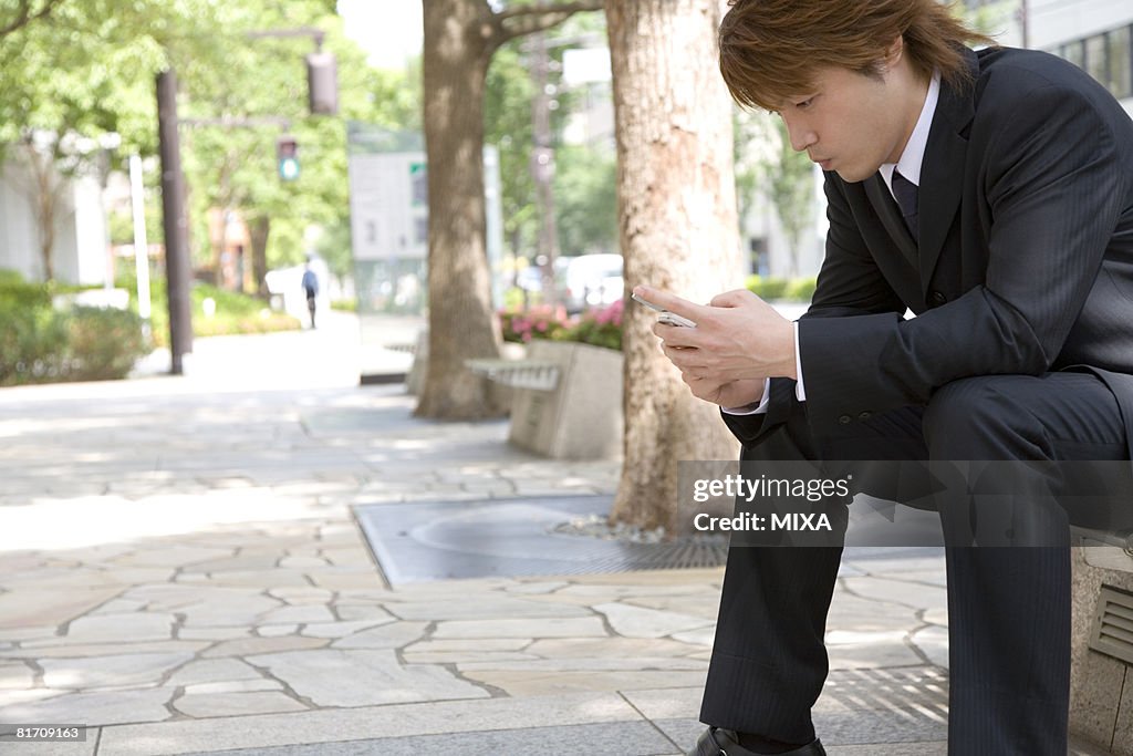 Young businessman looking at mobile phone