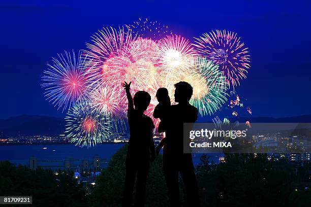 silhouette of family watching firework display - young man asian silhouette stock pictures, royalty-free photos & images