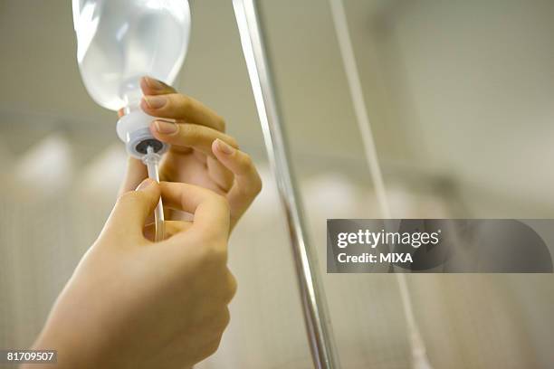nurse preparing iv drip - iv drip womans hand stock pictures, royalty-free photos & images