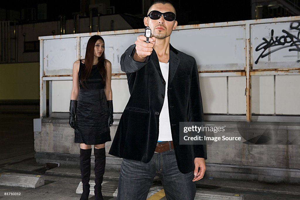 Japanese man aiming gun at camera