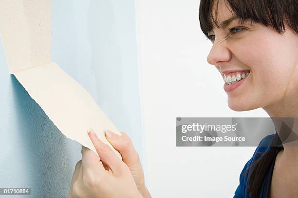 woman removing wallpaper - vrouw behangen stockfoto's en -beelden