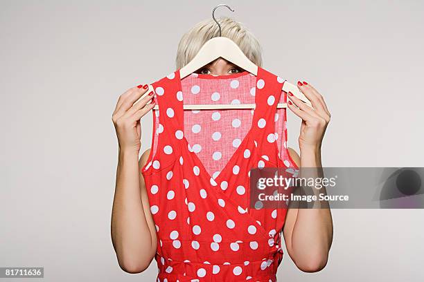 woman holding dress - coathanger foto e immagini stock