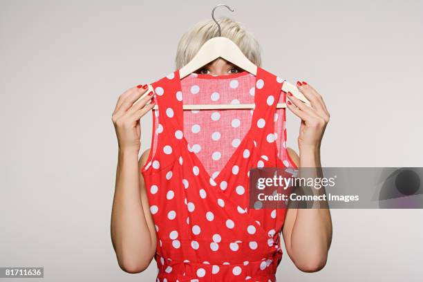woman holding dress - kledinghanger stockfoto's en -beelden