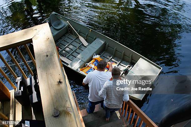 Kenny Lesley and John Holladay unload groceries from the boat to restock their home as it is surrounded by the flooding Mississippi River June 25,...