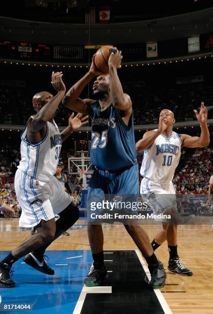 Al Jefferson of the Minnesota Timberwolves looks for the shot under pressure against Adonal Foyle and Keith Bogans of the Orlando Magic during the...