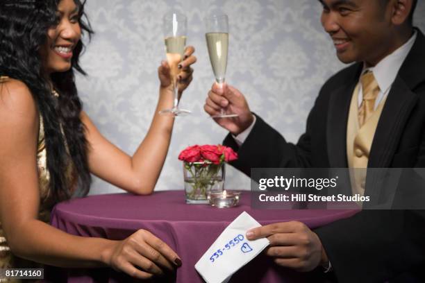 multi-ethnic couple toasting with champagne - phone number stock pictures, royalty-free photos & images