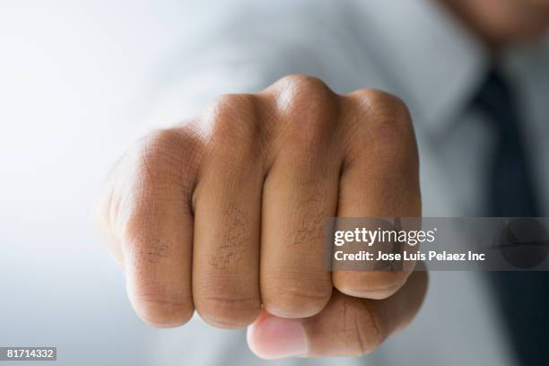 mixed race man making fist - nocca foto e immagini stock