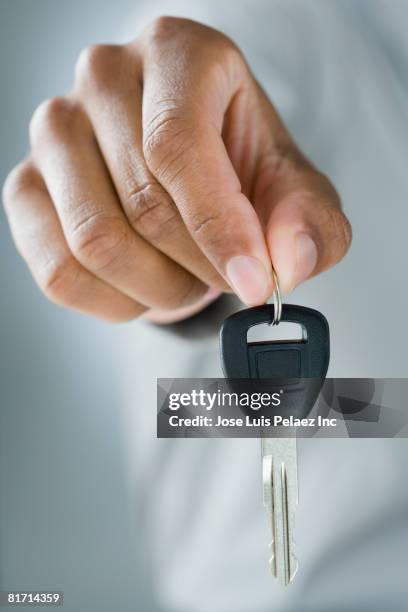 mixed race man holding car key - car keys hand stockfoto's en -beelden