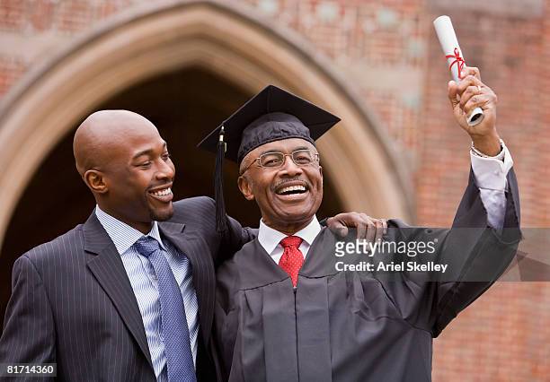 african man hugging graduate father - masters degree fotografías e imágenes de stock