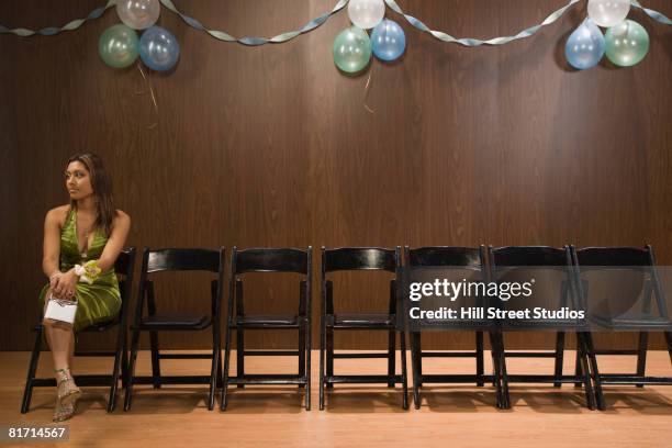 hispanic teenaged girl sitting alone at prom - sólo una adolescente fotografías e imágenes de stock