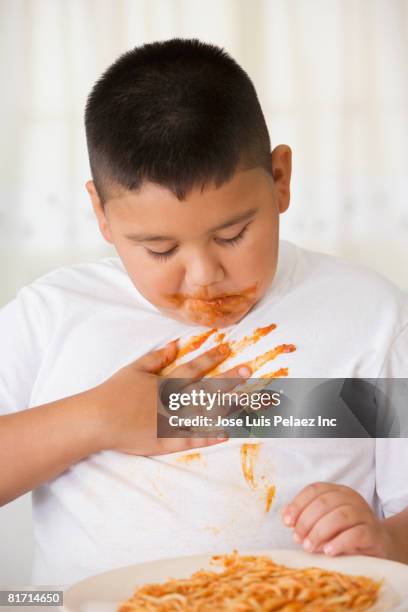 hispanic boy eating spaghetti - rubbing stock pictures, royalty-free photos & images