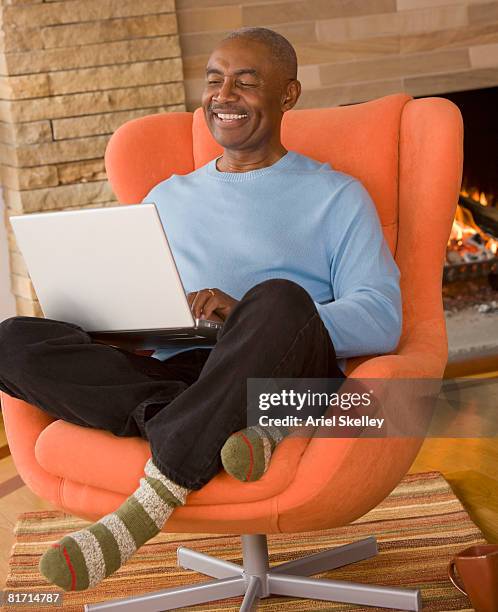 senior african man typing on laptop - barefoot black men stock pictures, royalty-free photos & images