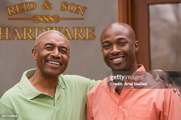 african father and adult son in front of business - small town community stock pictures, royalty-free photos & images