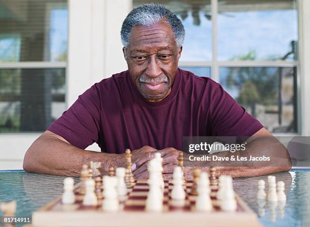 senior african man playing chess - senior playing chess stock pictures, royalty-free photos & images