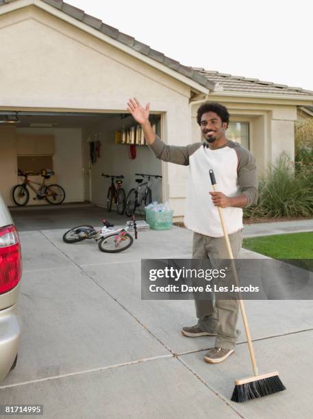 african man sweeping driveway - clean garage stock pictures, royalty-free photos & images