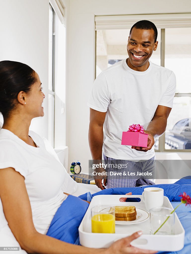 African man giving gift to wife